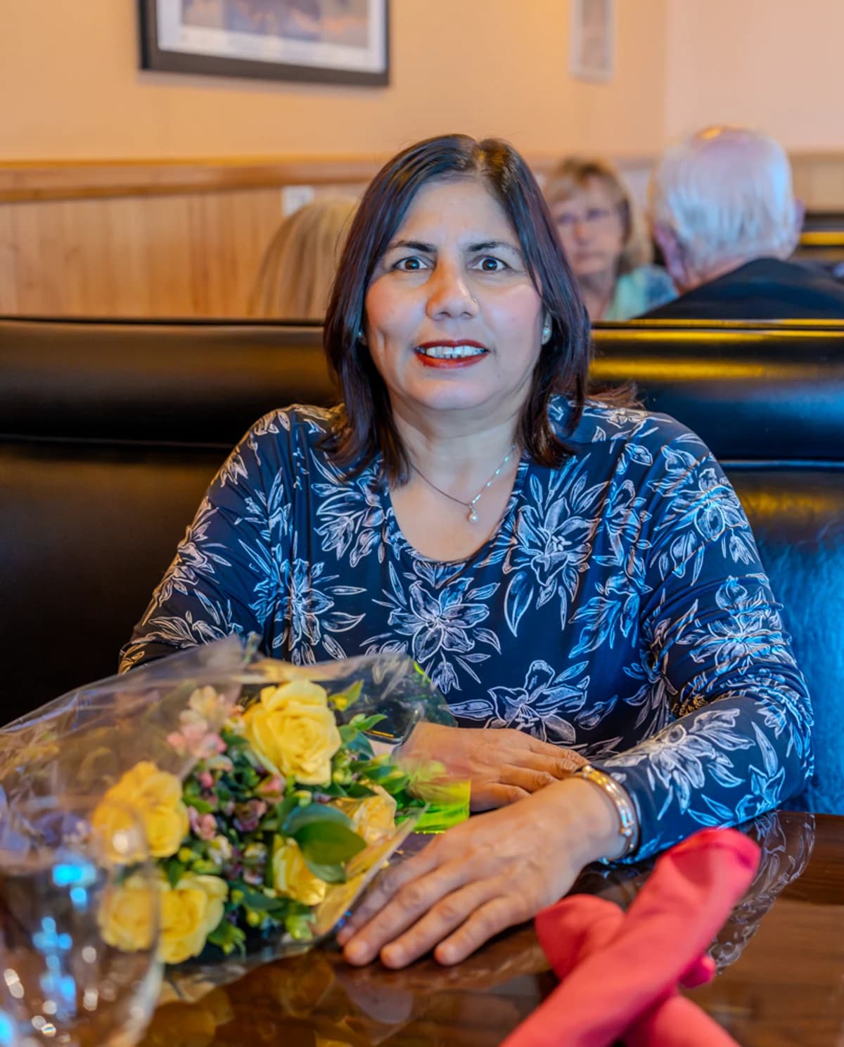 A mother holding fresh roses at Tandoori Kitchen